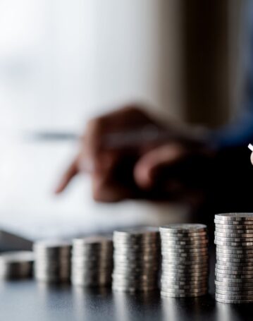 business-man-putting-a-coin-on-a-pile-of-coins-2025-01-16-22-01-48-utc-scaled